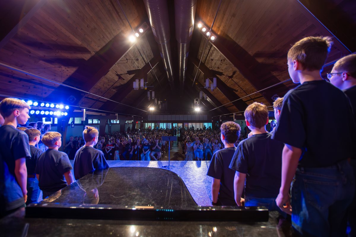 Young singers looking out at the audience from the stage